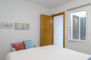 - une chambre avec un lit blanc et une fenêtre dans l'établissement Casa Roman, à Punta de Mujeres
