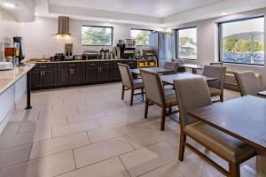 cocina y comedor con mesas y sillas en Wingate by Wyndham Fishkill en Fishkill