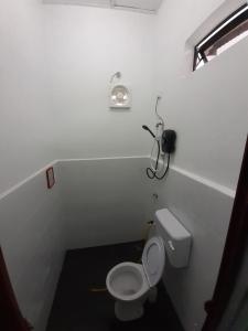 W pokoju znajduje się biała łazienka z toaletą. w obiekcie Tiny House Idaman Kuala Terengganu with Private House w mieście Kuala Terengganu