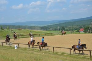a group of people riding horses on a dirt track at Hotel Jaśmin 