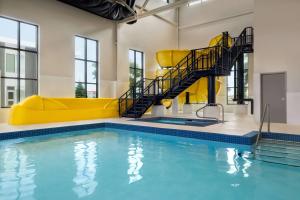 a swimming pool with a yellow slide in a building at Microtel Inn & Suites Montreal Airport-Dorval QC in Dorval