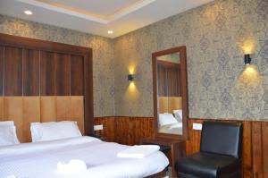 a bedroom with a bed and a mirror and a chair at Hotel Outlook in Pahalgām