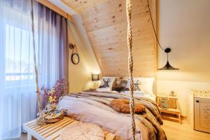 a bed in a room with a wooden ceiling at Willa Klimek Jacuzzi&Sauna in Poronin