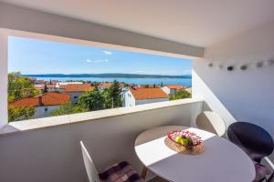 a room with a white table and a large window at Apartments PERA in Selce
