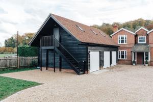 a black and white house with a garage at The Woodpecker - 1 Bedroom Annexe in Harpsden
