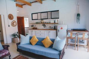 a living room with a blue couch and a kitchen at The Boho Cave in Cape Town