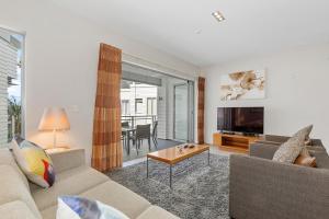 un soggiorno con divano e TV di The Waterfront - Paihia Holiday Apartment a Paihia