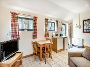 a living room with a table and a tv at The Tack Room - Uk36660 in Goulsby