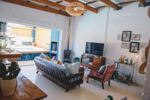 a living room with a couch and chairs and a television at The Boho Cave in Cape Town