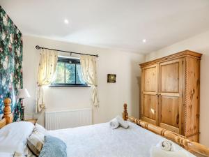 um quarto com uma cama grande e um armário de madeira em Betty Hutton - Uk36661 em Goulsby