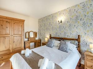 a bedroom with a large bed with blue and yellow wallpaper at Juice Trump - Uk36670 in Goulsby