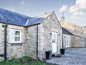 an old stone house with a white door at Clover Hill Farm in Coanwood