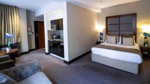 a large hotel room with a bed and a couch at Wellington Hotel by Blue Orchid in London +40 photos