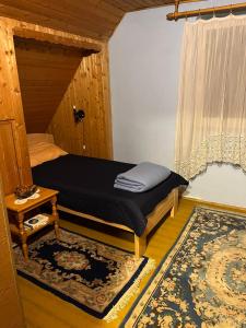 a small bedroom with a bed and a window at Zelena oaza in Divčibare