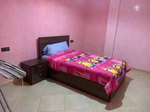 Dormitorio rosa con cama con manta rosa en اقامة السعادة en Monte ʼArrouit