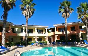 a resort with a swimming pool and palm trees at Residence con piscina a Palau, a soli 150 mt. dal mare in Palau