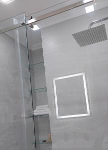 ducha con puerta de cristal y ventana en Apartament Vip Chirie, en Chişinău