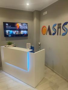 ein Büro mit einer Rezeption und einem TV an der Wand in der Unterkunft Oasis in Acitrezza