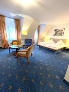 ラーベンスブルクにあるレブガルテンホテル シュールガッセのベッド、テーブル、椅子が備わるホテルルームです。