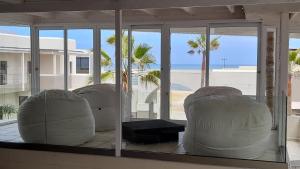 a room with white chairs and a view of the beach at Atlantic Villa Boutique Guesthouse in Swakopmund
