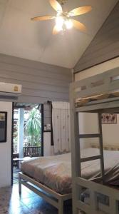 um quarto com 2 beliches e uma ventoinha de tecto em LUCKY PAI Resort&Hostel em Pai