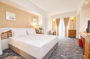 a bedroom with a large white bed and a television at Dedeman Palandoken Ski Lodge Hotel in Erzurum