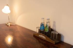 a wooden tray with three bottles and glasses on a table at Hotel Jaśmin in Regetów Niżny