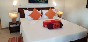 a bedroom with a large white bed with two lamps at Rockside Cabanas Hotel in Unawatuna