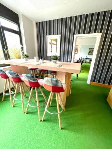 una mesa y sillas en una habitación con alfombra verde en Rebgarten Hotel Schulgasse, en Ravensburg