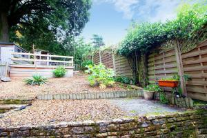 a garden with a fence and a stone wall at Station Lodge close to City Centre with parking in Exeter