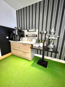 a kitchen with green flooring and a counter with a table at Rebgarten Hotel Schulgasse in Ravensburg