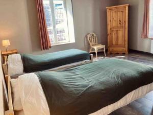 a bedroom with two beds and a chair and a window at Le Nordmann - au coeur de Gérardmer in Gérardmer