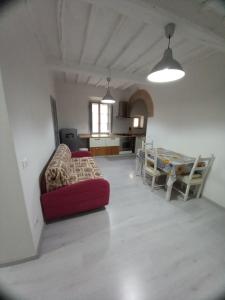 ein Wohnzimmer mit einem roten Sofa und einem Tisch in der Unterkunft L' Antico Comune in Cavriglia