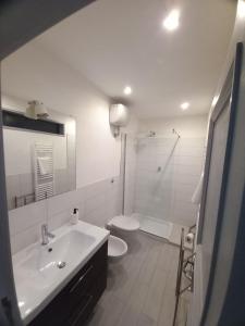 a white bathroom with a sink and a toilet at L' Antico Comune in Cavriglia