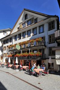 a building with people sitting at tables in front of it at Hostel Engelberg in Engelberg