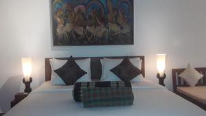a bedroom with a bed with two lamps on it at Rockside Cabanas Hotel in Unawatuna