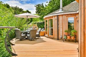a deck with a table and chairs and a gazebo at Finest Retreats - Buzzard Luxury Treehouse Hideaway in Dittisham