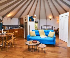 a living room with a blue couch and a kitchen at Finest Retreats - Buzzard Luxury Treehouse Hideaway in Dittisham
