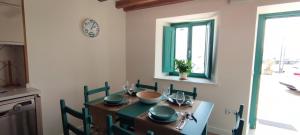 a dining room table with chairs and a clock on the wall at El balcón de Carmen in O Barqueiro