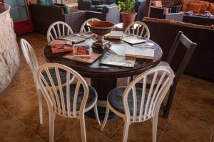 a wooden table with four chairs around it at Madaba Hotel in Madaba