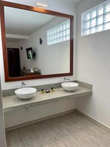 a bathroom with two sinks and a large mirror at Rockside Cabanas Hotel in Unawatuna