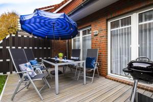 a blue umbrella on a deck with a grill at Kleine Meereskrabbe in Werdum