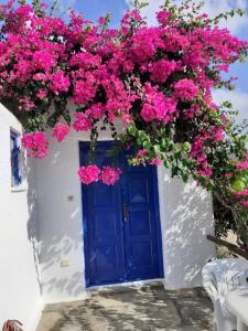 a blue door with pink flowers on a white building at Villas Kalafatis Apartments in Kalafatis