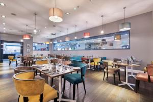 a restaurant with tables and chairs and a bar at Park Inn by Radisson Cardiff City Centre in Cardiff