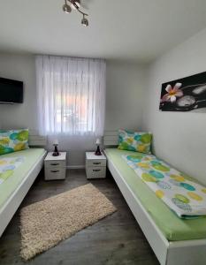 2 camas individuales en una habitación con ventana en Lemke-Ferienwohnung en Nordhorn