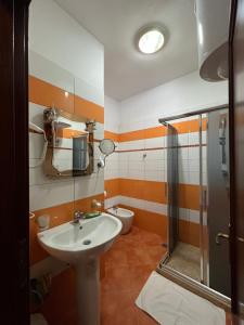 Un baño con lavabo, ducha e inodoro. en Bujtina Shqiptare, en Tirana 15 fotos más