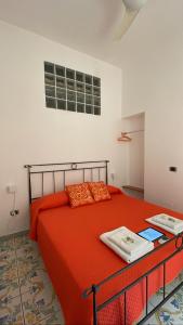 ナポリにあるQueen Carolina's Homes - Apartments in Old Townのベッドルーム1室(オレンジのシーツが入ったベッド1台、窓付)