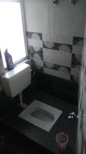 SHARTHI HOMESTAY AND LODGING في Namchi: حمام به مرحاض أبيض ونافذة