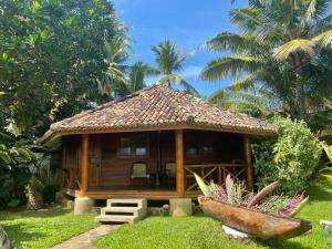 a small house in a yard with palm trees at Rockside Cabanas Hotel in Unawatuna