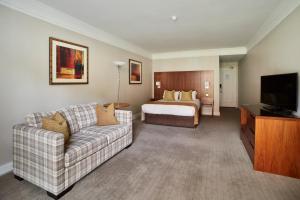 um quarto de hotel com um sofá e uma cama em Coldra Court Hotel by Celtic Manor em Newport